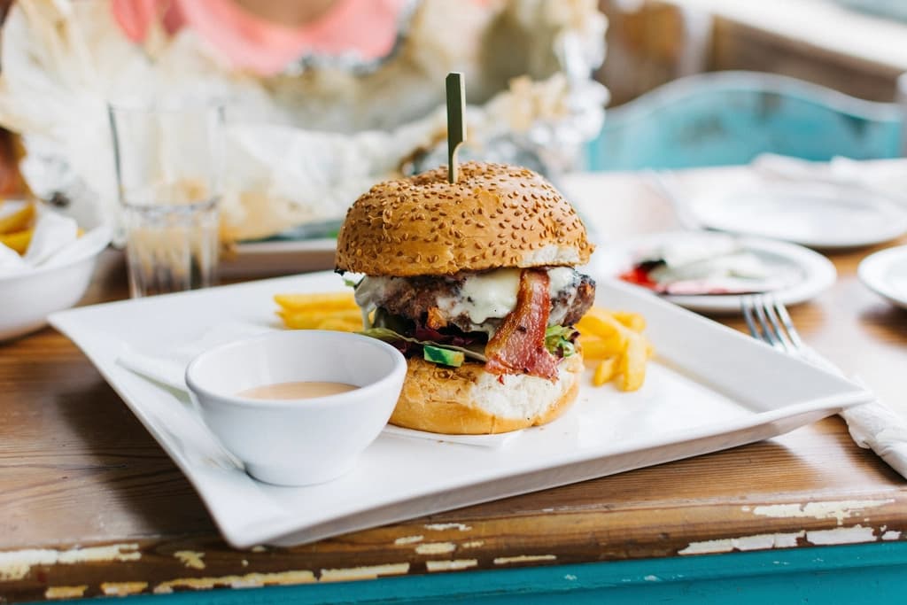 A burger with fries served on a white plate