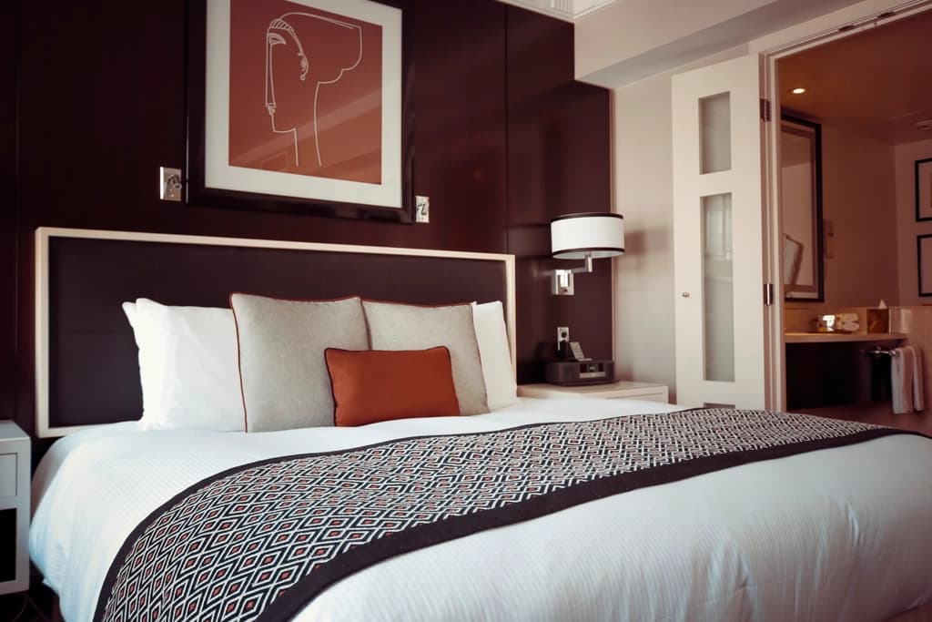 A neatly made bed in a modern hotel room